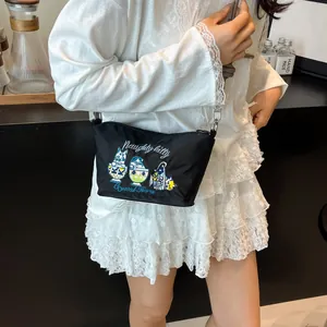 Detail of black crossbody bag with naughty kitty embroidery and metallic silver hooks