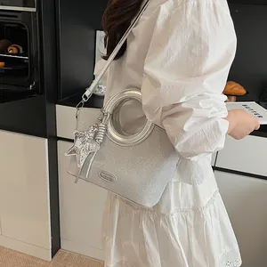 Détail du sac seau à paillettes argentées avec pendentif étoile et logo métallique