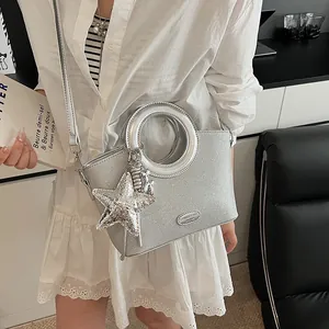 Sac seau pailleté argenté avec poignée anneau et breloque étoile porté en bandoulière