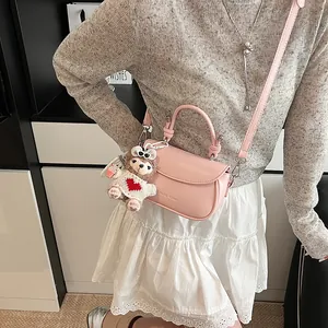 Vue détaillée du sac rose en cuir avec porte-clé ours en peluche et poignée ronde