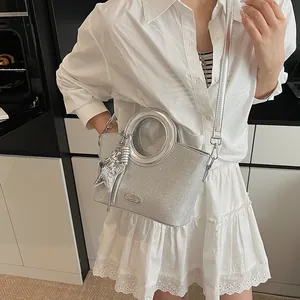 Détail du sac cabas à paillettes argentées avec poignée ronde, étoile et bandoulière