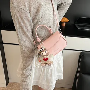 Petit sac à main rose avec charm ours en peluche présenté dans un décor mode moderne