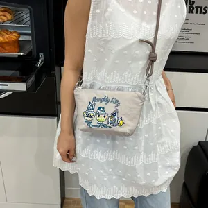 Detail of the Naughty Kitty cat embroidery on a small canvas shoulder bag for women