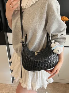 Fashion woven crescent bag in black with a plush star charm for casual styling