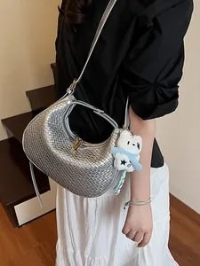 Silver woven crescent bag with bear pendant worn by model in a minimalist style