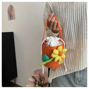 Dettaglio della borsa a secchiello arancione tessuta a mano con fiore giallo e coulisse