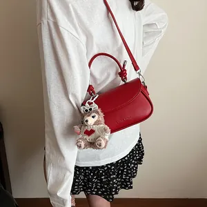 Sac bandoulière en cuir rouge avec poignée nouée et logo de marque style urbain