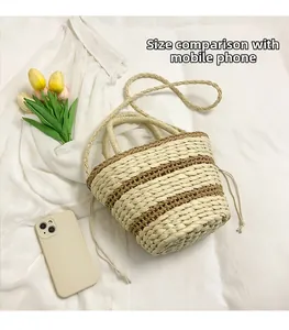 Detail of a beige and brown straw bucket bag with a phone for size comparison