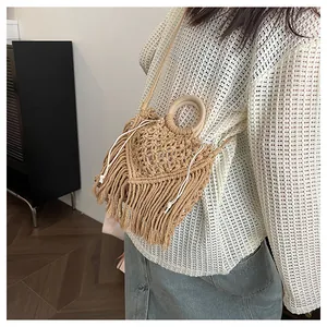 Detail showing handwoven bohemian tassel bag with crochet patterns and wooden handle