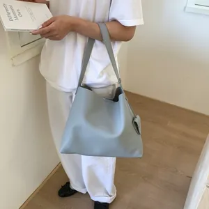 Detail view of light blue tote bag with matching pouch and premium pebbled texture