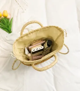 Vue détaillée de dessus du sac seau en paille tressée montrant sa grande capacité interne