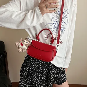 Détail du sac selle rouge avec gaufrage Chaleh Killer et accessoire charme ours peluche