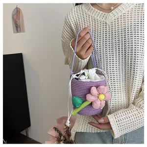 Dettaglio borsa a secchiello viola in paglia intrecciata a mano con decoro floreale rosa
