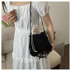 Detail of black crochet handbag with circular wooden handles and long fringe tassels