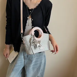 Détail du sac seau à imprimé léopard argenté avec poignée ronde rose et étoile