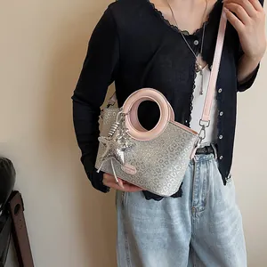 Détail du sac seau à paillettes léopard argentées avec anses roses et étoile