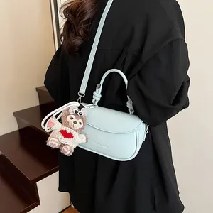 Sac à main bleu clair en similicuir avec un charmant ours en peluche sur la bandoulière