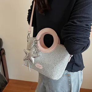 Vue détaillée du sac seau à paillettes argentées motif léopard avec poignée ronde rose et étoile