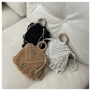 Close-up of woven bohemian tassel bags with round wooden handles in three colors