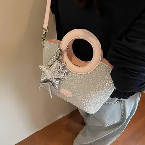 Détail du sac seau léopard à paillettes argentées avec poignée ronde rose et charms