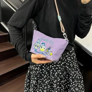 Close-up of a purple crossbody bag featuring detailed cat embroidery and braided strap