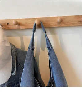Close-up of durable wide shoulder strap on blue denim tote bag with reinforced stitching