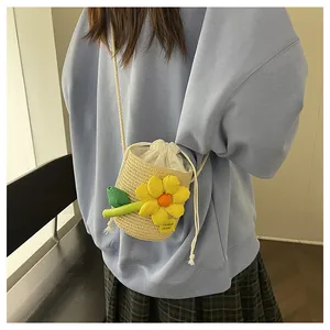 Dettaglio mini borsa a secchiello in paglia con fiore 3D giallo e tracolla in cotone