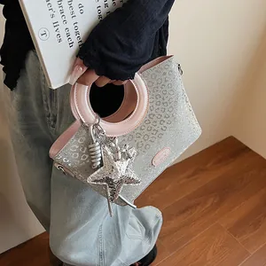 Vue détaillée du sac seau à paillettes léopard avec poignée rose et breloque étoile