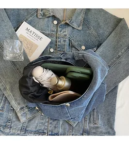 Spacious interior of denim shoulder bag showing umbrella, phone, and water bottle