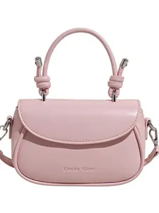 Sac à bandoulière rose chic avec rabat incurvé et poignée à nœud sur fond blanc éclatant