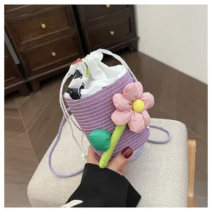 Dettaglio di un secchiello intrecciato viola con grande fiore rosa e coulisse bianca