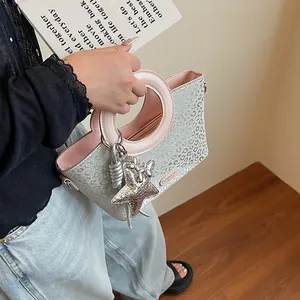 Détail du sac seau argenté à motif léopard avec doublure rose et breloque étoile