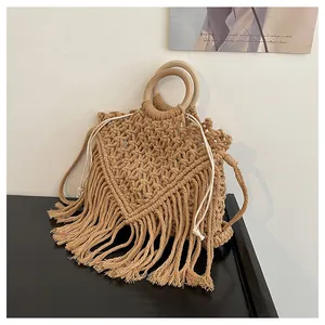 Detail of bohemian woven bag featuring long tassels and natural wooden circular handles