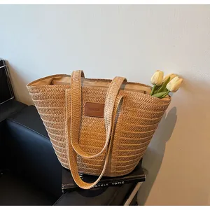 Grand sac cabas en paille tressée kaki avec étiquette en cuir marron et bandoulière