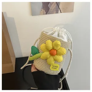 Dettaglio della borsa a secchiello in paglia intrecciata con girasole e coulisse