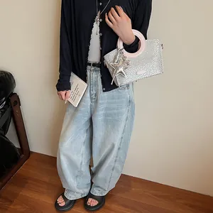 Sac seau à paillettes léopard argenté avec poignées roses porté par un mannequin avec style