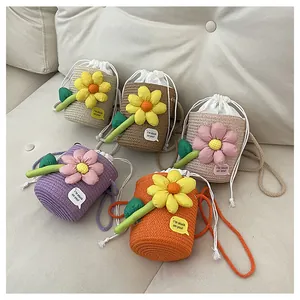 Dettaglio di mini borse a secchiello intrecciate con fiori 3D e chiusure a coulisse