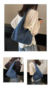 Detail of blue denim hobo bag with metal snap button and large capacity design