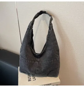 Detail der grauen Denim-Einkaufstasche mit nahtlosem Gurt und Vintage-Nähten am Stoff