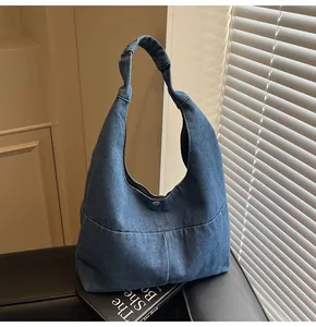 Detailansicht der dunkelblauen Denim-Hobo-Tasche mit einem silbernen Magnetverschluss