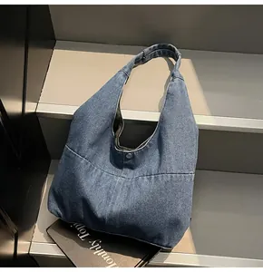 Detailaufnahme der dunkelblauen Denim-Einkaufstasche mit Metallverschluss auf Magazin