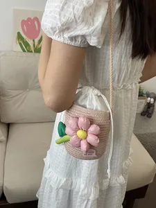 Mini borsa a secchiello intrecciata con grande fiore rosa e coulisse per vacanze al mare