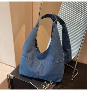 Detailansicht der dunkelblauen Denim Hobo-Tasche mit Fokus auf Textur und Nähten