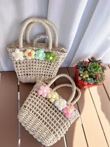 Detailed macro view of handmade woven straw bags with colorful 3D crochet flower ornaments
