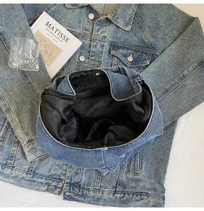 Internal structure of blue denim tote bag with black lining, zipper pocket and magnetic snap