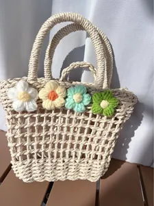 Detailed macro view of handcrafted floral accents on beige woven straw handbag