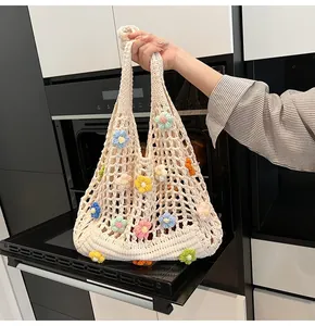 Dettaglio della trama in maglia della borsa all'uncinetto con fiori 3D colorati