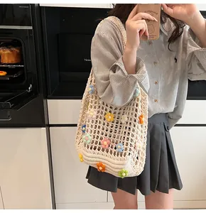 Dettaglio della borsa tote all'uncinetto con fiori 3D colorati e trama a rete aperta
