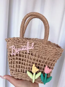 Close-up of khaki woven tote with pink Beautiful embroidery and fabric tulips