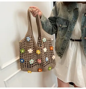 Dettaglio della borsa tote all'uncinetto con fiori 3D colorati e trama a maglia traforata